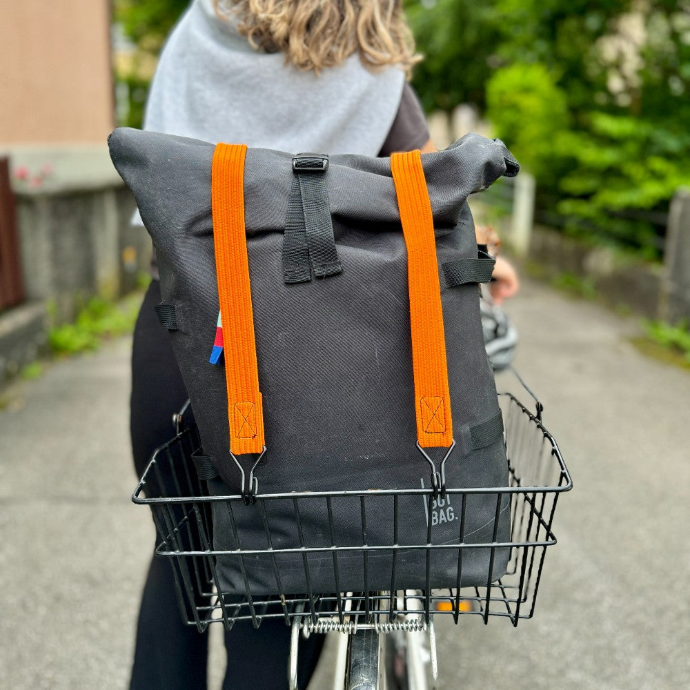 Velokorb mit einem Rucksack, welcher mit zwei Gummizügen festgespannt ist. 
